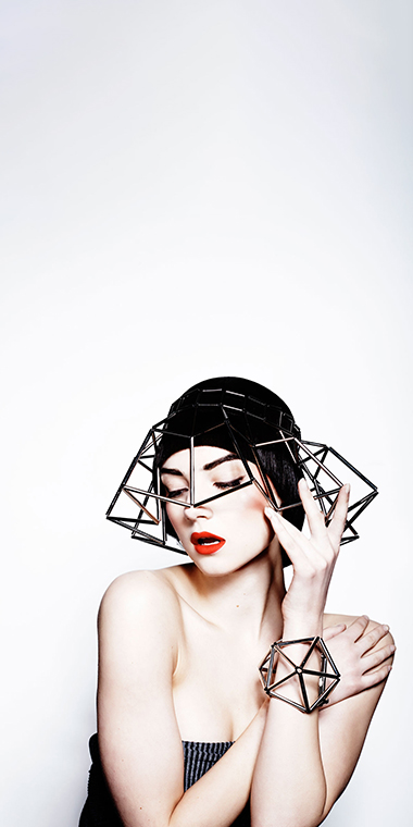 Avant-garde fashion styling with geometric headpiece and bold red lipstick