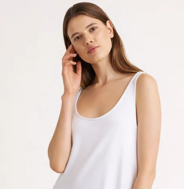 Model wearing a white dress with refined garment fit and natural fabric presentation