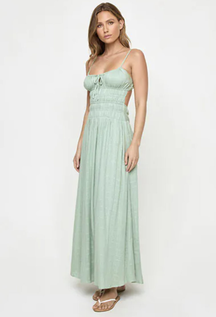 Full-length fashion photograph of a model wearing a pale mint green sleeveless maxi dress with a flowing skirt.